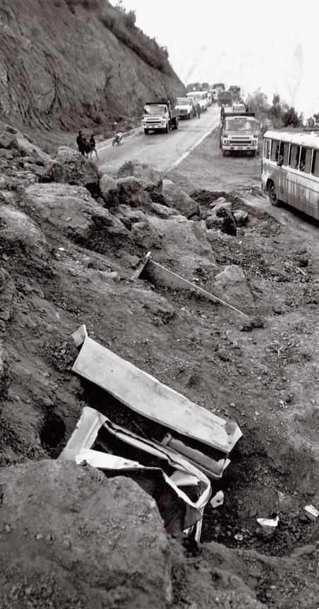 1985年7月,昆洛公路化念坡段,被坍塌的山体埋没的大货车以及交通阻断后滞留在路上的车辆和行人。在大自然面前,公路这种人工建筑物十分脆弱。